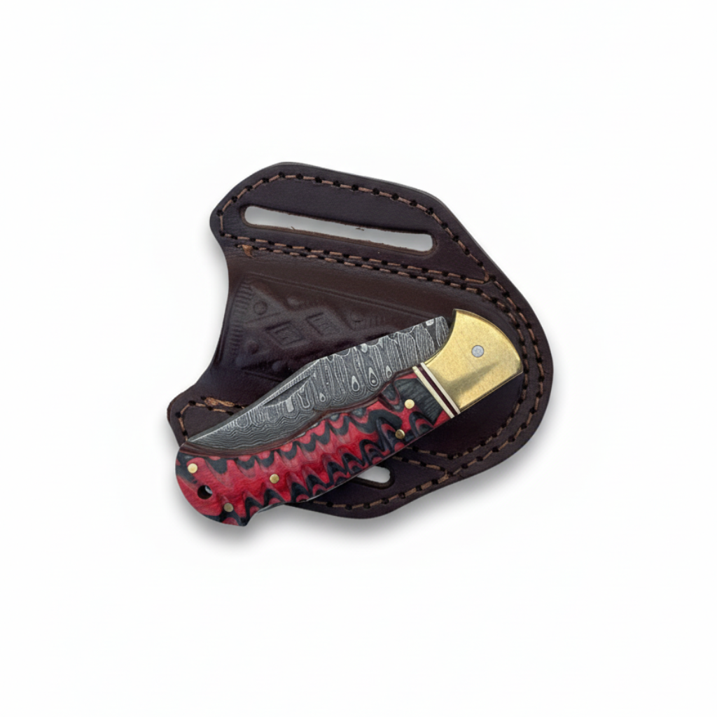 Folding knife with red and black patterned blade in a leather sheath on a white background