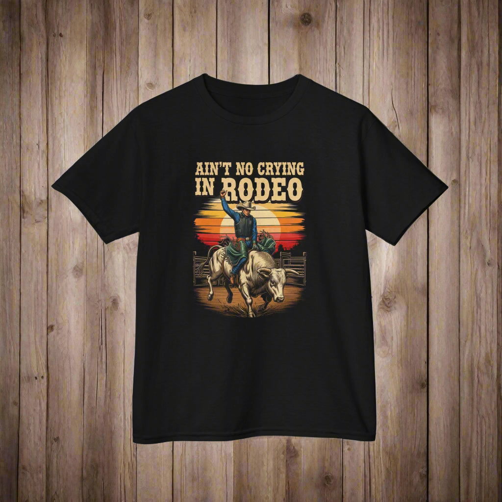 Black t-shirt with a graphic of a person riding a bull and text 'Ain't No Crying in Rodeo' on a white background