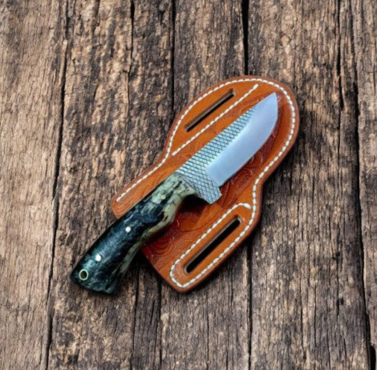 Knife with a brown leather sheath on a wooden surface