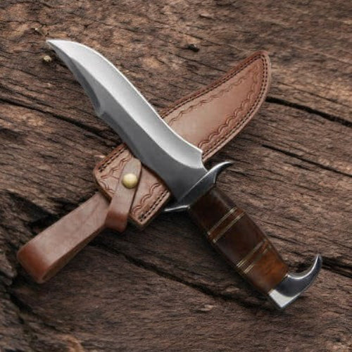Knife with brown handle and leather sheath on a wooden surface