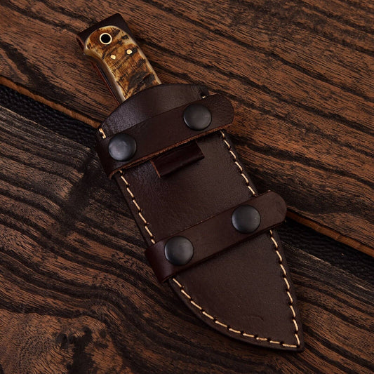 Brown leather knife sheath with wooden handle on a wooden surface
