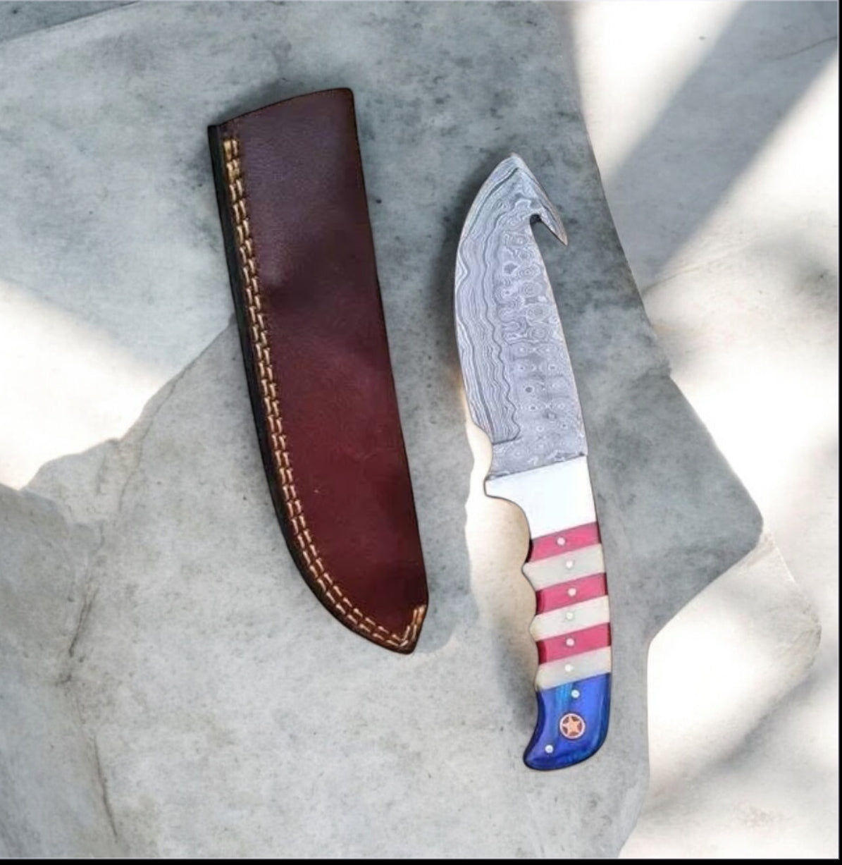 Knife with a colorful handle and leather sheath on a textured surface