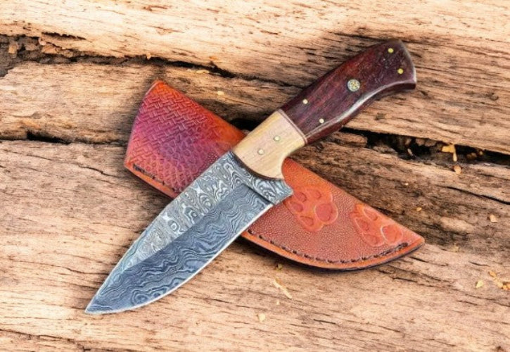 Decorative knife with a wooden handle and leather sheath on a wooden surface