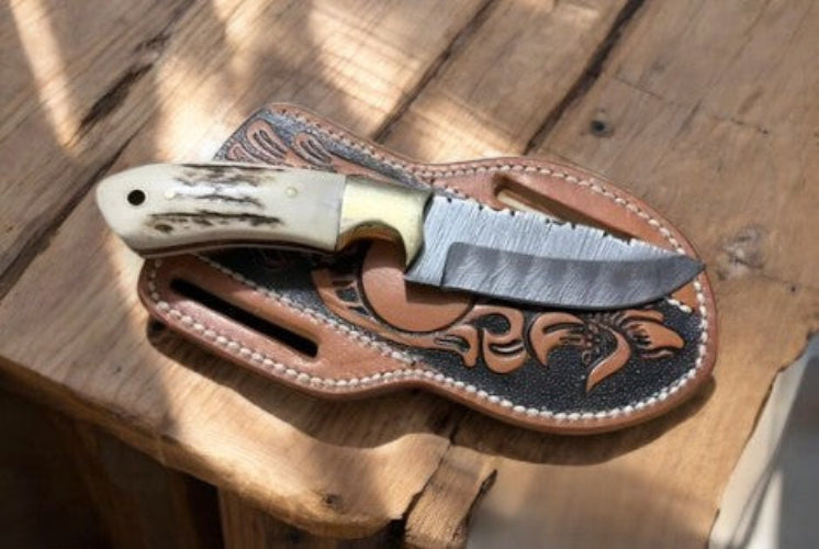 Knife with a decorative sheath on a wooden surface