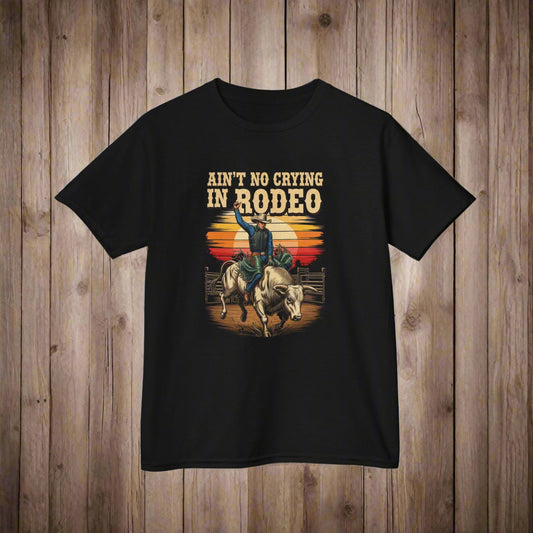 Black t-shirt with a graphic of a person riding a bull and text 'Ain't No Crying in Rodeo' on a white background