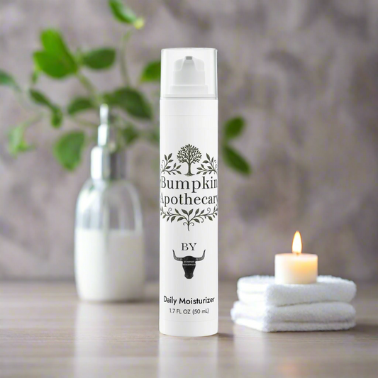Bumpkin Apothecary daily moisturizer bottle on a table with a candle and plant in the background