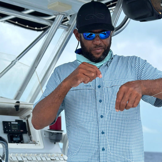 Man on a boat wearing sunglasses and a checkered shirt