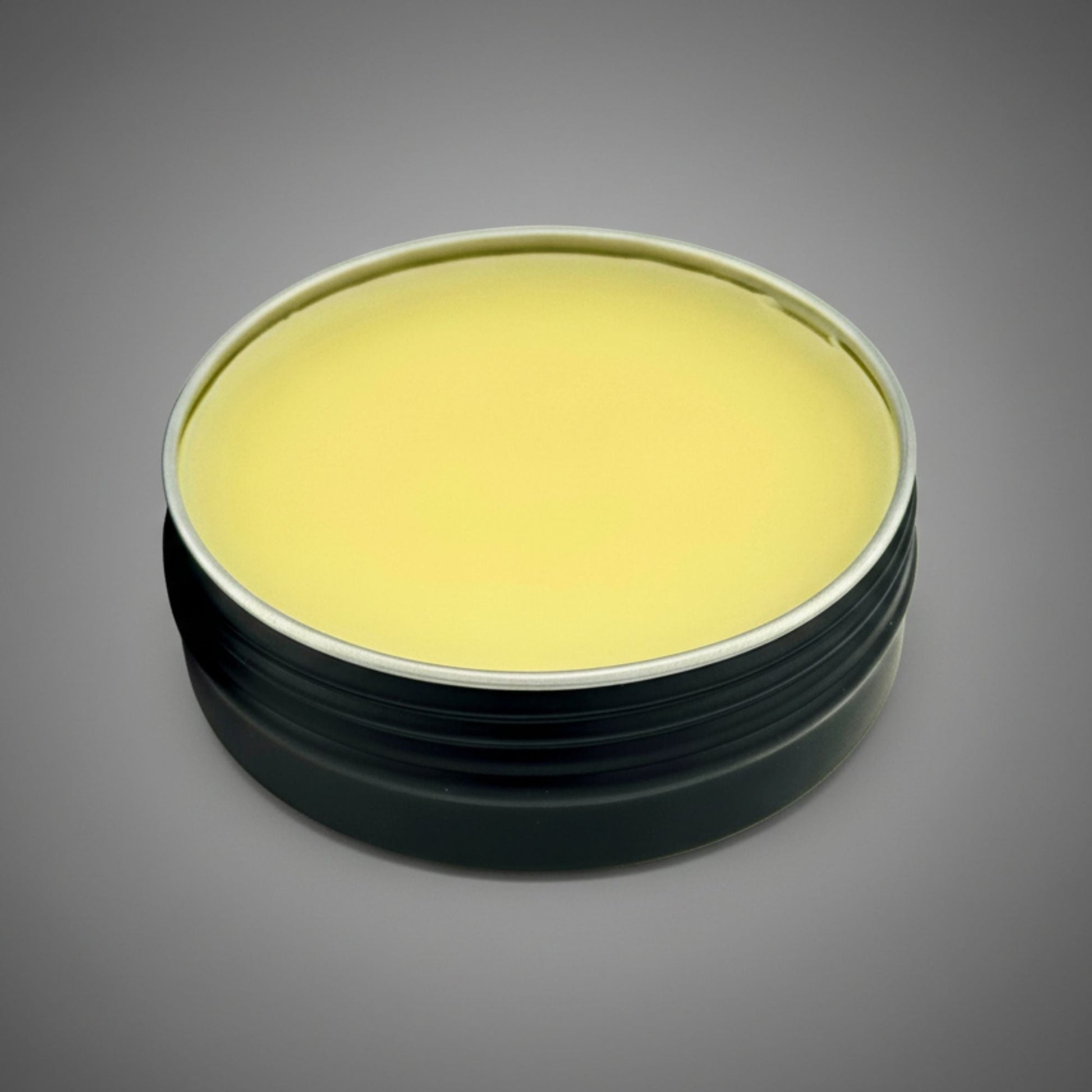 Round container with a yellow lid on a gray background