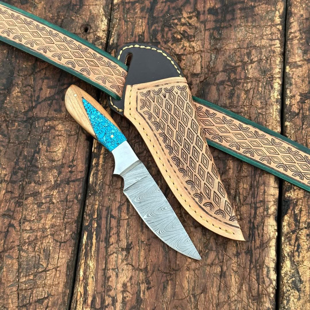 Decorative knife with turquoise handle and leather sheath on wooden surface