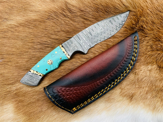 Decorative knife with turquoise handle and leather sheath on a fur background