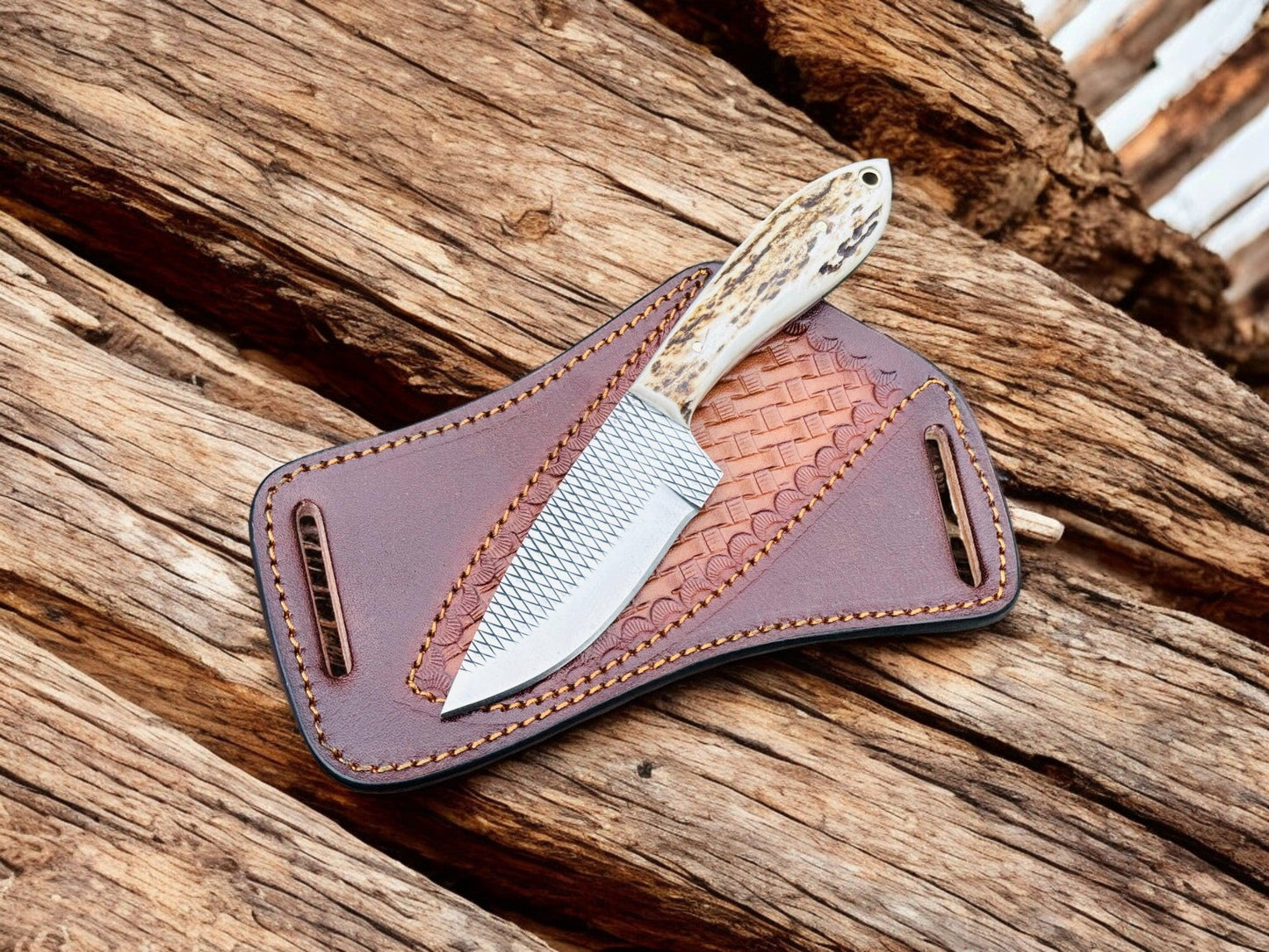 "Handmade cowboy knife with a rasp tool steel blade and antler handle, displayed on a leather sheath with a woven pattern."