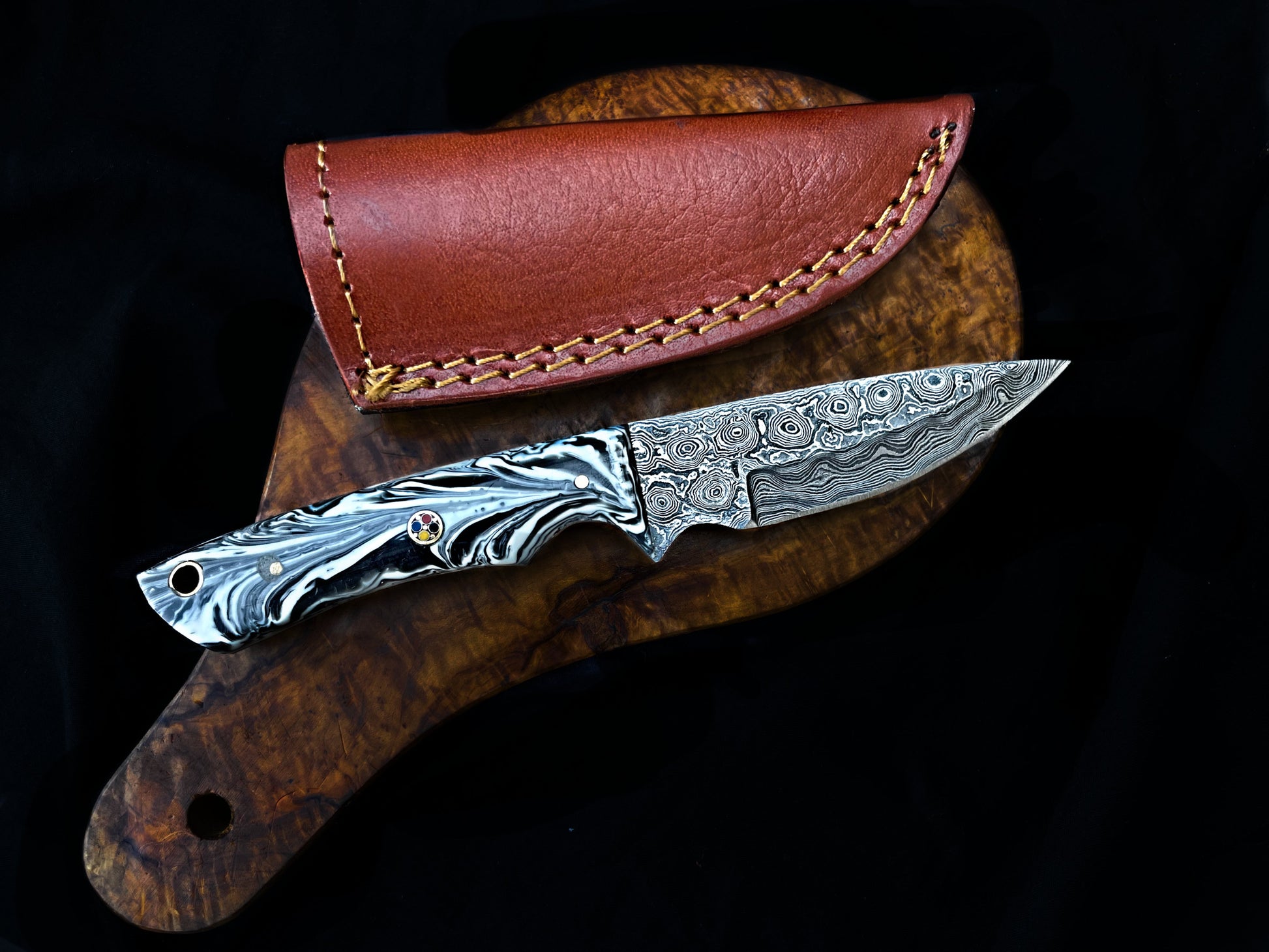 Decorative knife with a detailed blade and brown leather sheath on a dark background