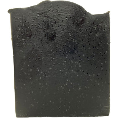 Black soap bar with a textured surface on a white background