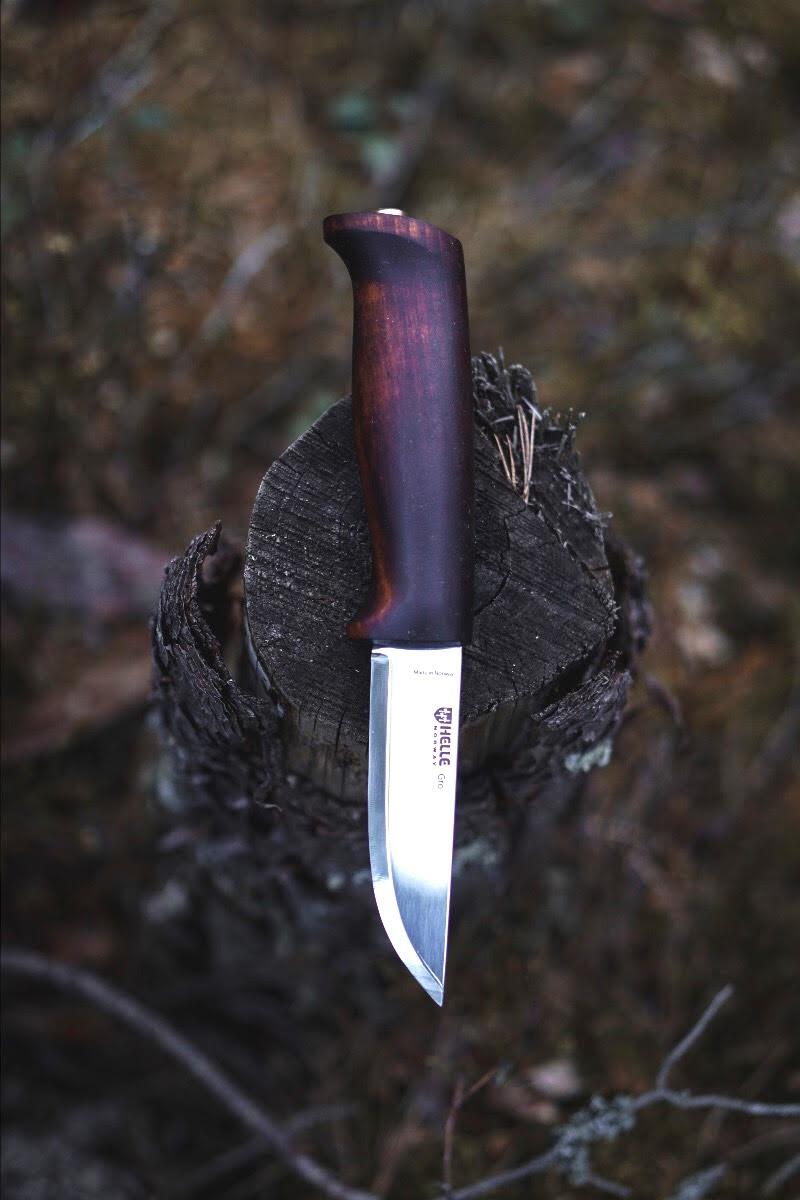 Knife with a wooden handle on a tree stump in a forest setting