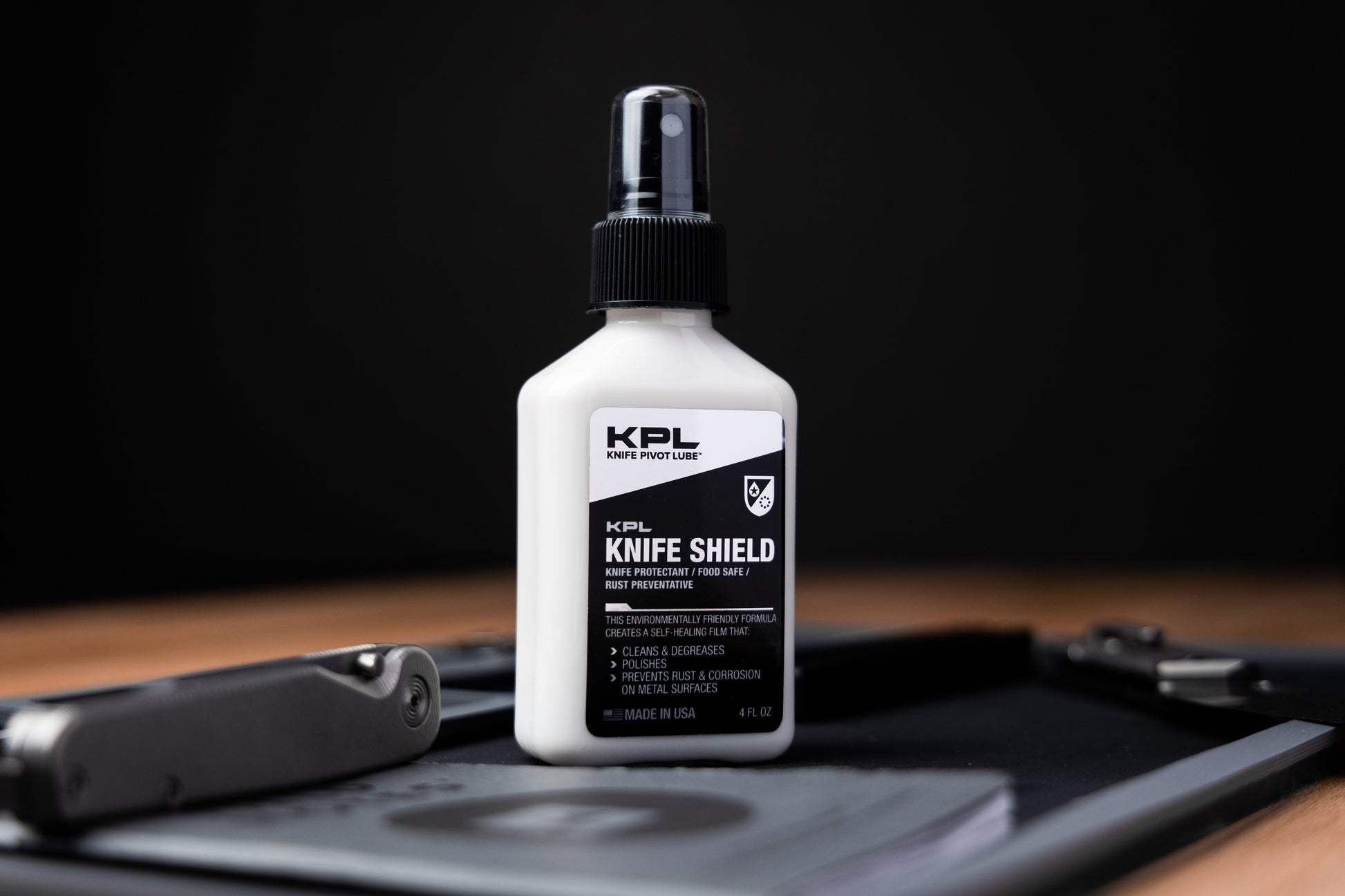 KPL Knife Shield bottle on a wooden surface with a knife in the background
