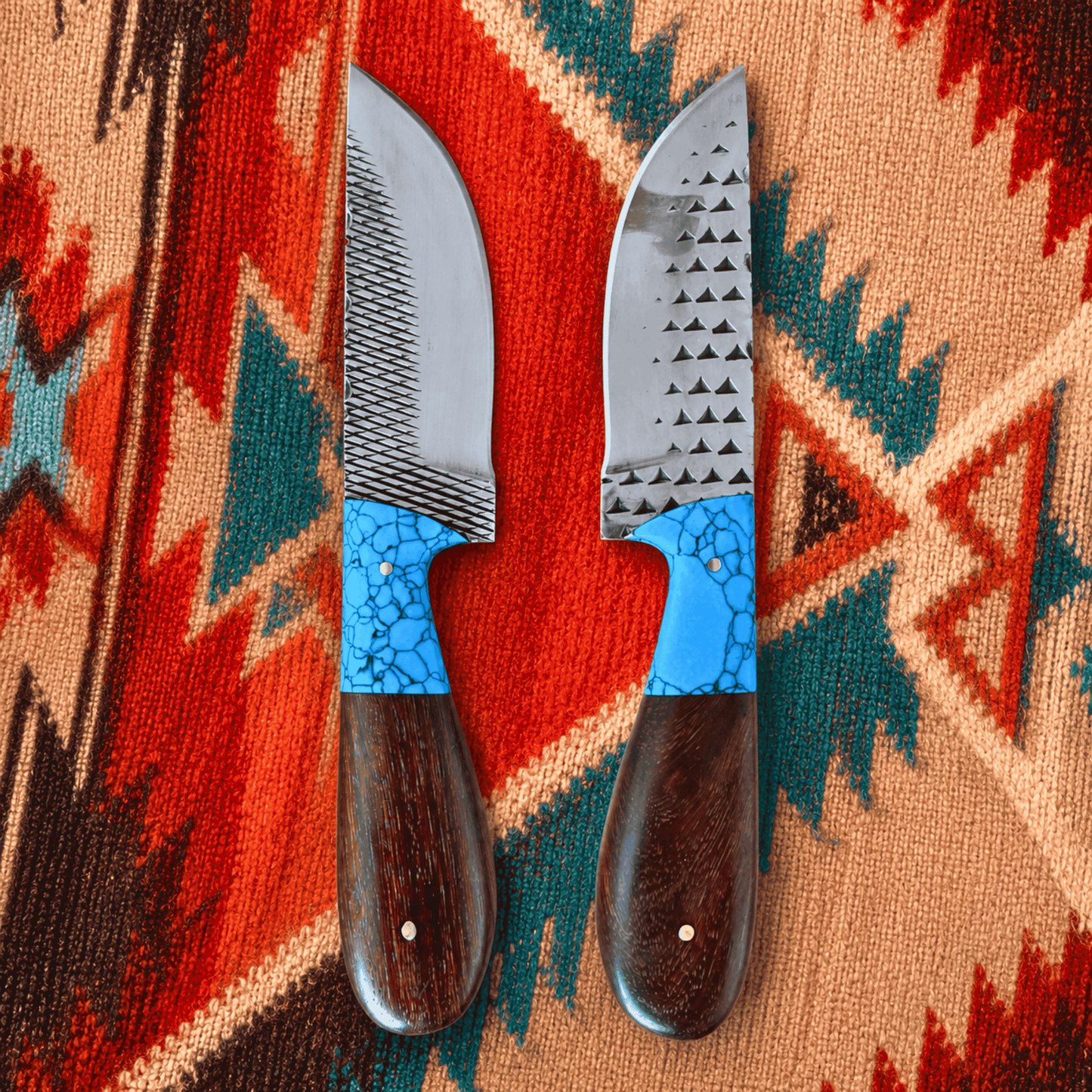 Two rasp steel cowboy knives with textured silver blades and bright blue mosaic handles, displayed on a colorful Southwestern-style woven rug.