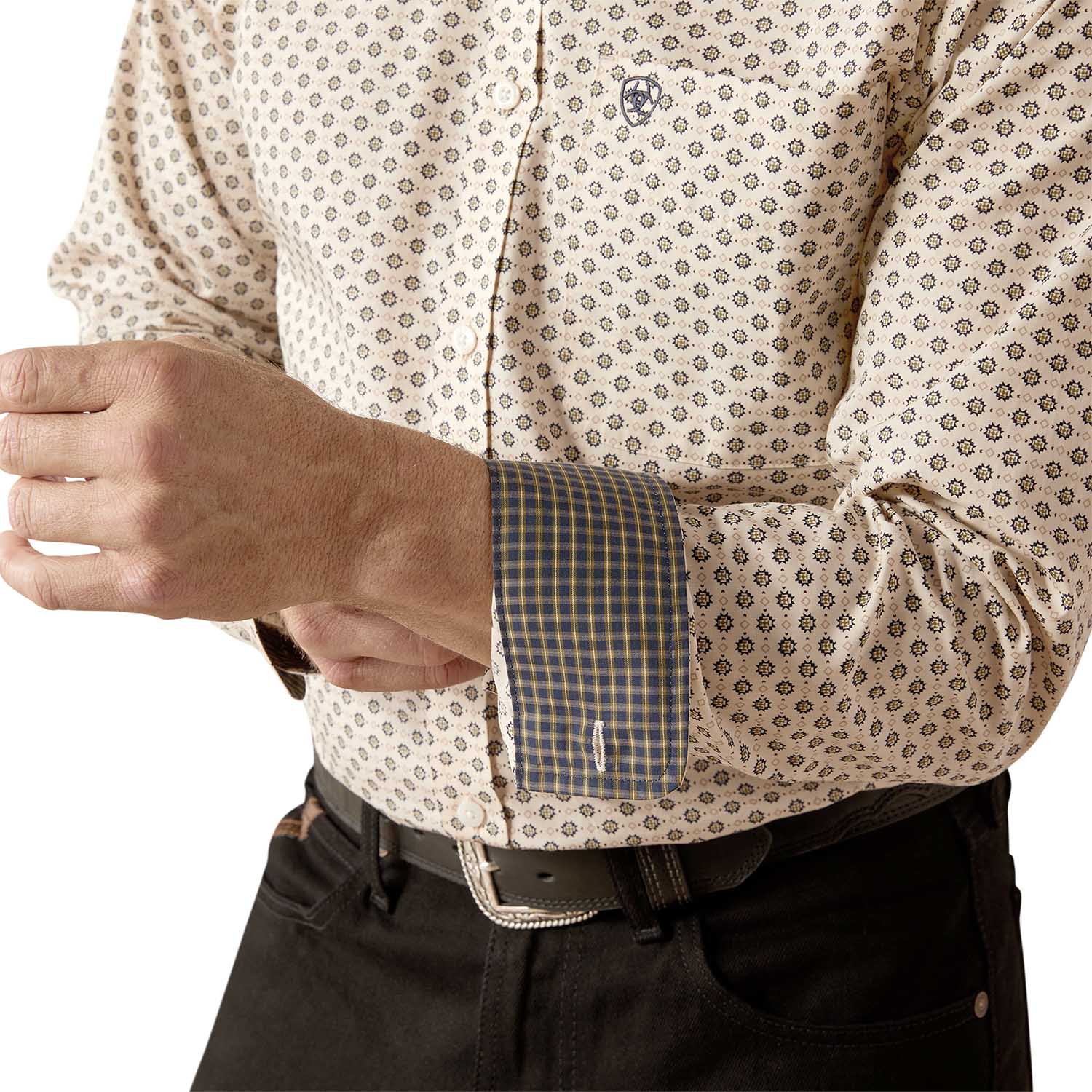 Close-up of a person wearing a patterned shirt with rolled-up sleeves on a white background