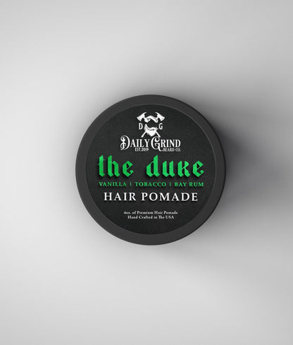 Hair pomade container labeled 'the duke' by Daily Grind on a white background