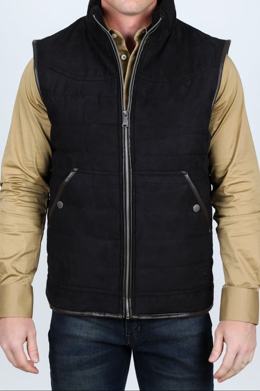 Man wearing a black vest over a beige shirt on a white background