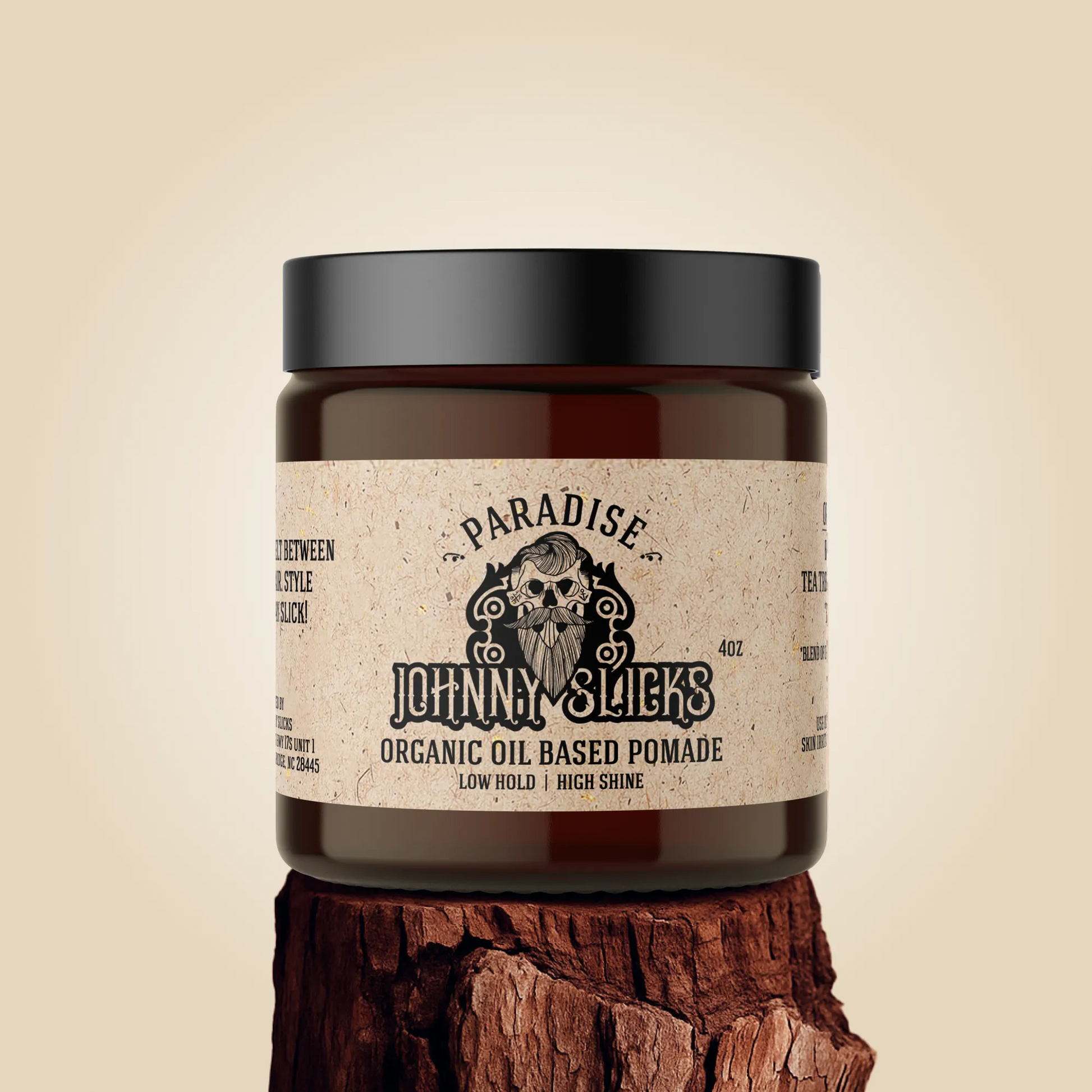 Jar of Johnny Slicks organic oil-based pomade on a wooden block with a beige background